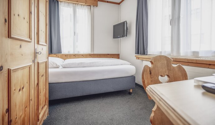 Bright single room with desk | © Davos Klosters Mountains