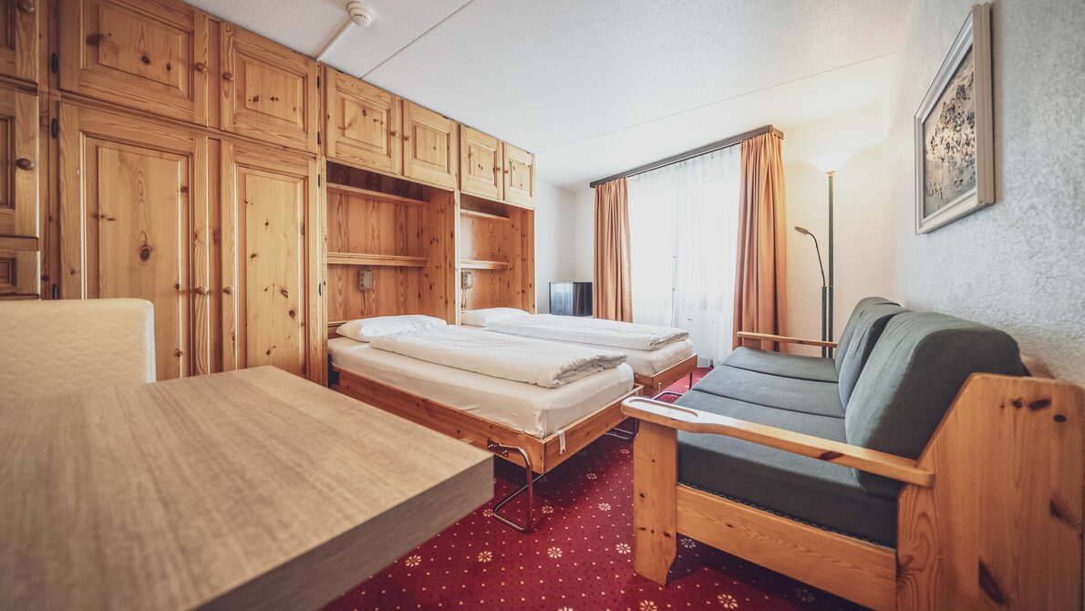 Grosses 2-Bettzimmer mit Arvenholzeinrichtung, Sofa und Esstisch | © Davos Klosters Mountains Grosses 2-Bettzimmer mit Arvenholzeinrichtung, Sofa und Esstisch | © Davos Klosters Mountains