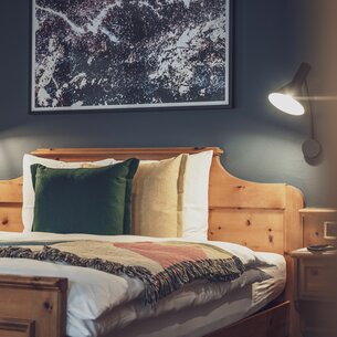 Hotel bed with bed lamp | © Davos Klosters Mountains